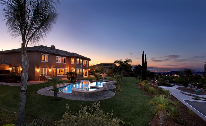 Luxury house with pool at dusk overlooking city lights