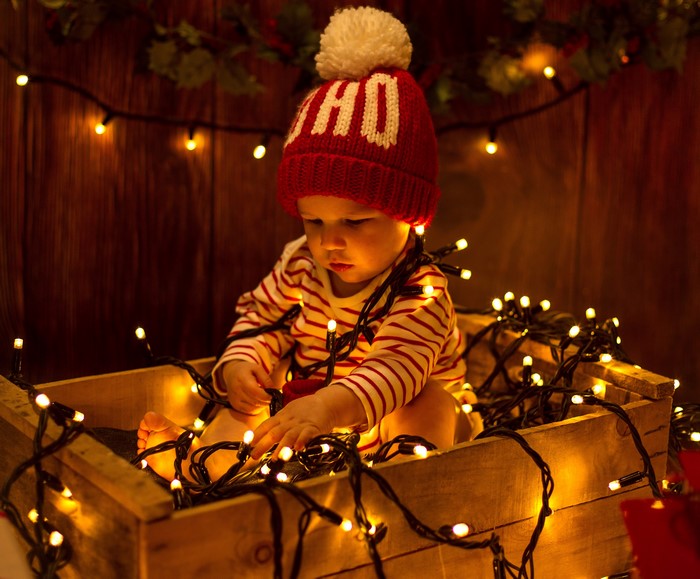Baby in Christmas hat with fairy lights