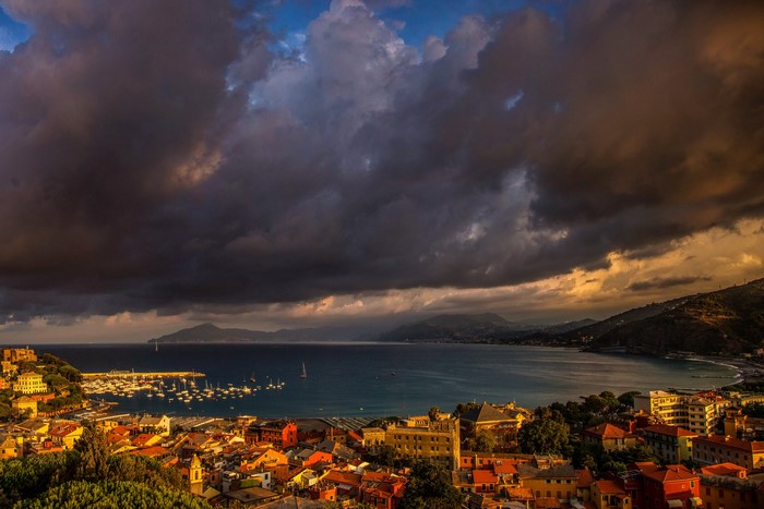 Coastal town with harbor and stormy clouds
