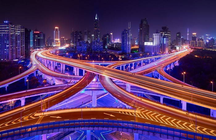 City highway interchange at night with light trails