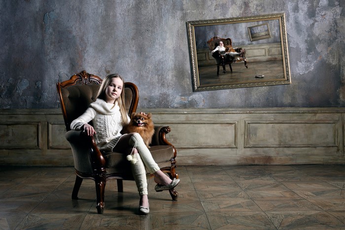 Girl and dog sitting in an armchair