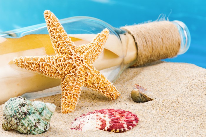 4K Starfish and Shells on Sand with Message in a Bottle