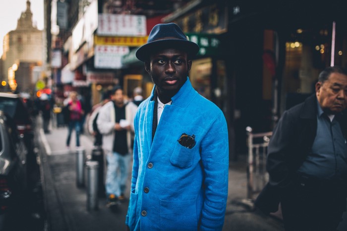 Man in blue jacket and hat on a city street