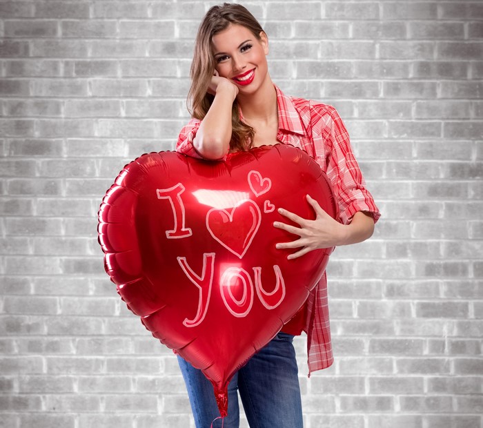 Woman holding a red heart balloon