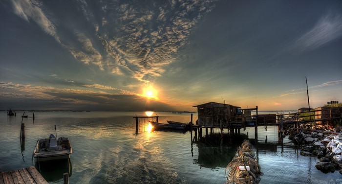 Sunset over Scardovari with boats and fishing huts