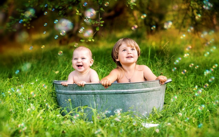 Two babies in a tub with bubbles