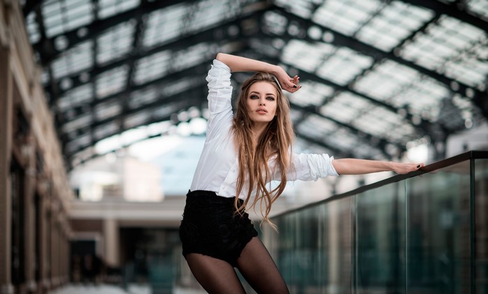 Woman in white shirt and black shorts posing
