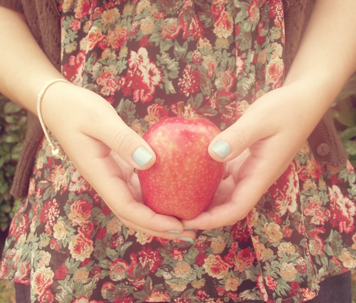 Hands holding a red apple
