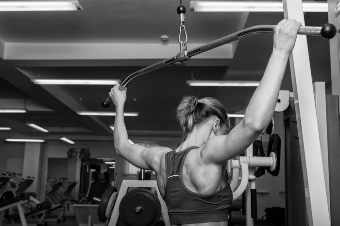 Woman exercising on a lat pulldown machine in a gym