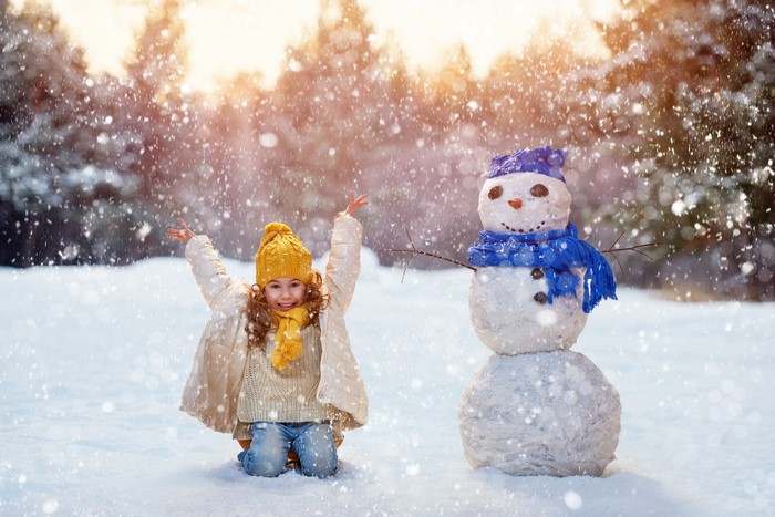 Girl and Snowman in Falling Snow
