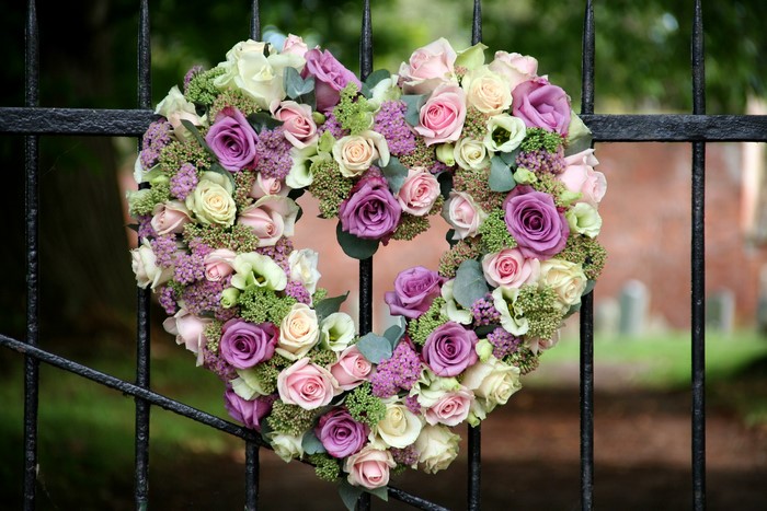 Heart-shaped floral arrangement on a fence