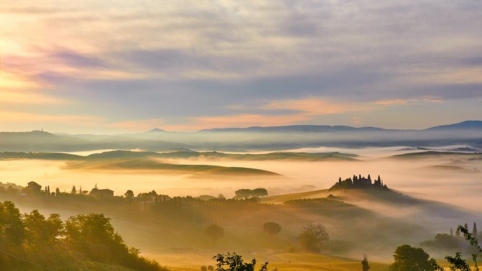 Tuscany landscape with fog at sunrise