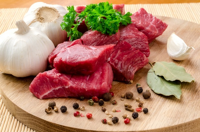 Raw meat with garlic and spices on a cutting board