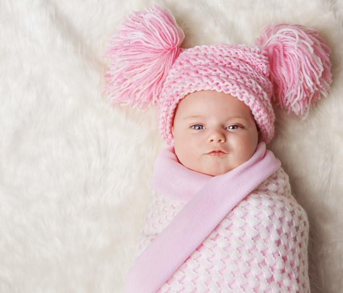 Baby wearing a pink winter hat and blanket