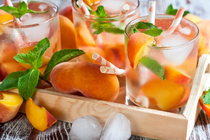 Peach iced tea with mint and ice in glasses