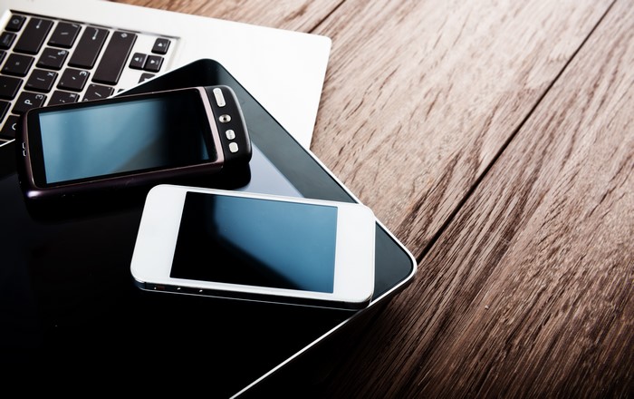 Smartphones and Laptop on Wooden Table