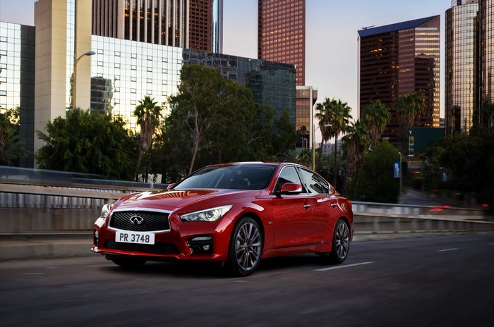 Red 2016 Infiniti Q50S driving in city