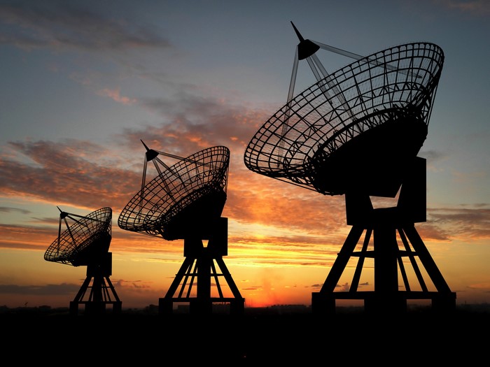 Radio telescopes silhouetted against sunset sky