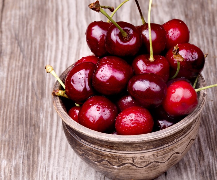 Bowl of fresh cherries with water droplets