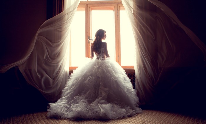 Bride in a white dress by the window
