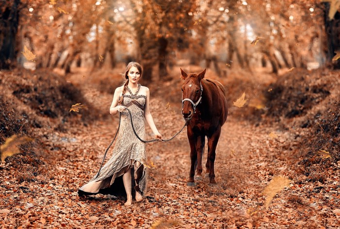 Woman with horse in autumn forest
