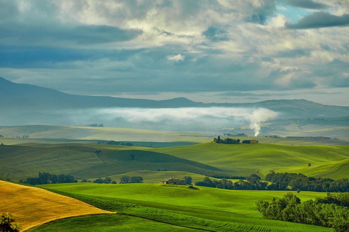 Tuscany landscape with rolling green hills and clouds
