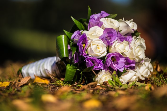 Bouquet of white roses and purple eustoma on the ground