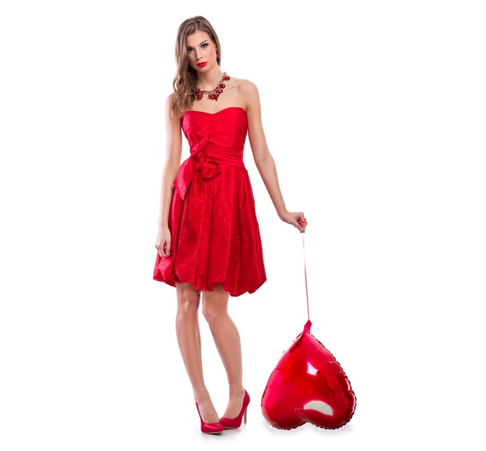 Woman in red dress holding a heart balloon