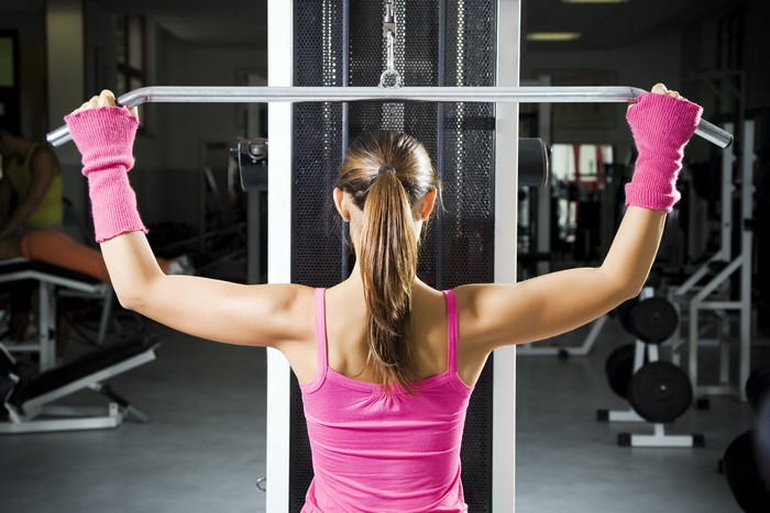 Woman working out on a lat pulldown machine