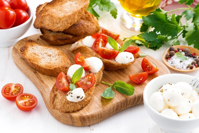 Bruschetta with tomatoes and mozzarella on a wooden board