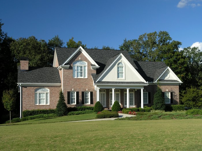 Brick house with white columns and manicured lawn