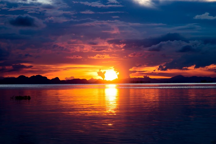 Sunset over a calm body of water with mountains