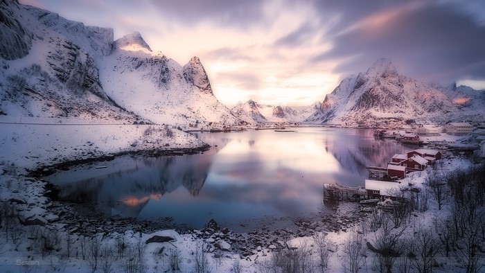 Snowy mountains and lake with red houses