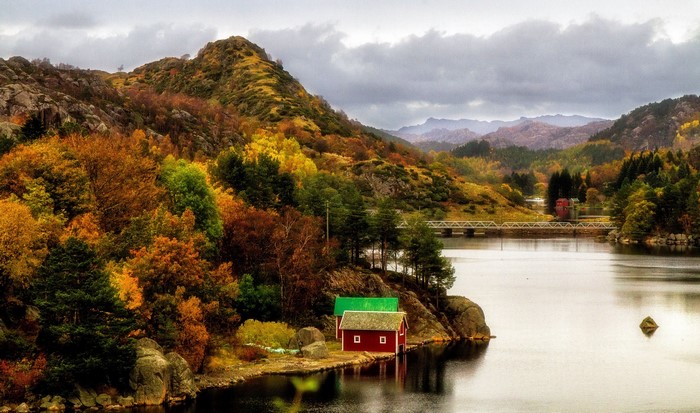 Autumn landscape with red houses by a lake in Norway