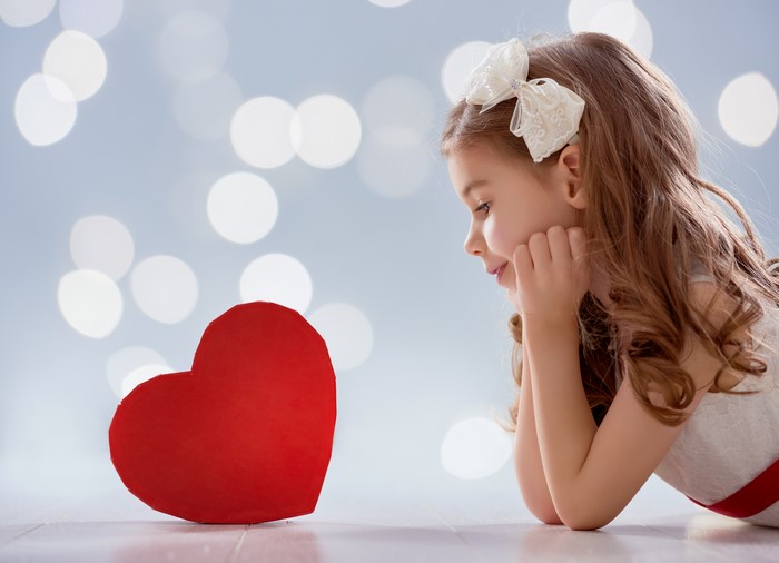 Girl with a red heart and bokeh background