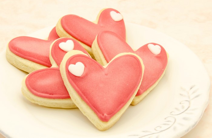 Heart-shaped cookies with pink icing on a plate