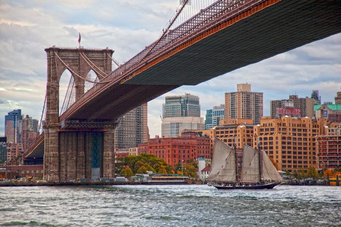 Brooklyn Bridge and sailboat on East River, New York City