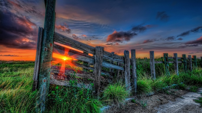 Wooden fence at sunset with sun rays