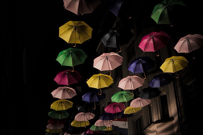 Many colorful umbrellas hanging at night in Luxembourg