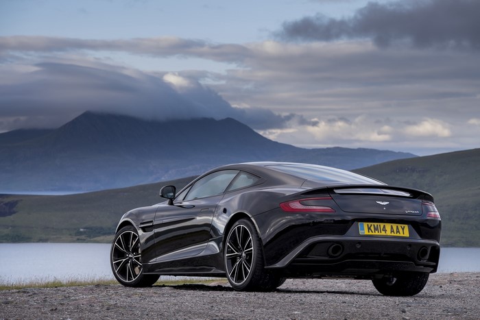 Black Aston Martin Vanquish parked by a lake
