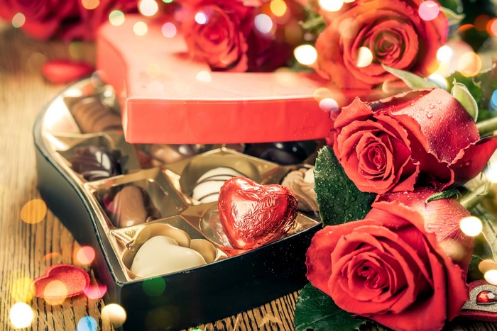 Heart-shaped box of chocolates and red roses