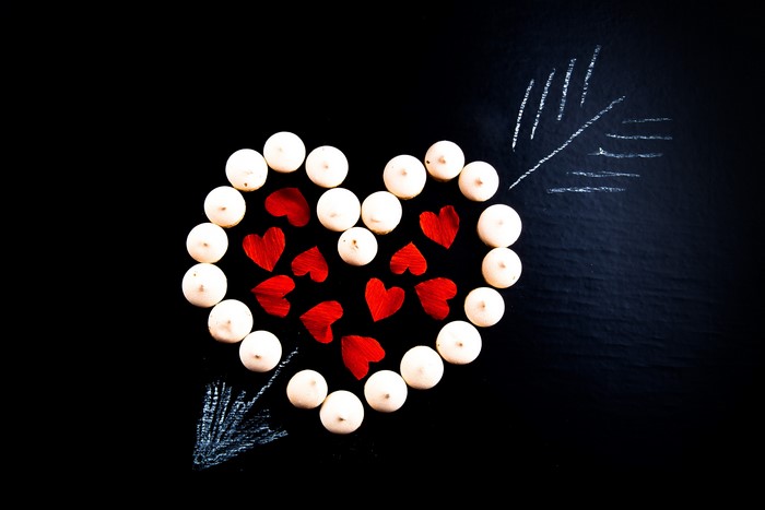 Heart shape made of meringues and red hearts with chalk arrow