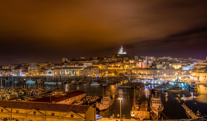 Night view of Marseille harbor with Notre-Dame de la Garde
