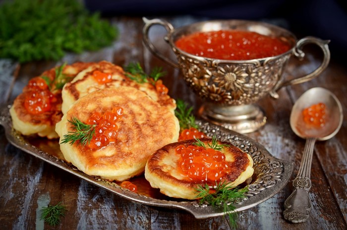 Pancakes with red caviar and dill