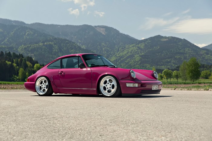 Violet Porsche 964 parked with mountains in the background