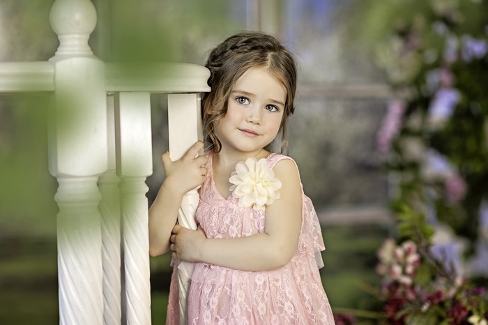 Young girl in a pink dress with a flower