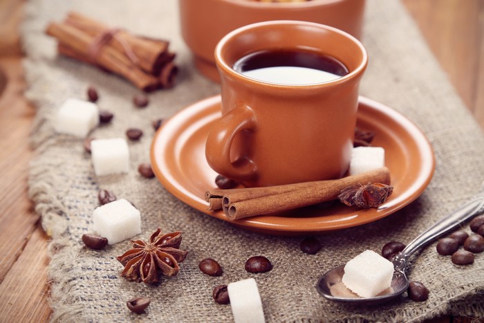 Coffee with cinnamon sticks and sugar cubes