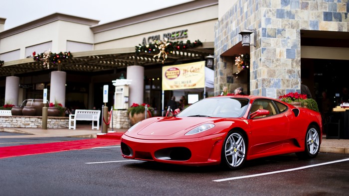 Red Ferrari F430 parked on a red carpet