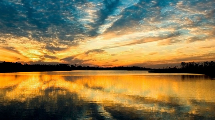 Sunset over a calm lake with colorful clouds