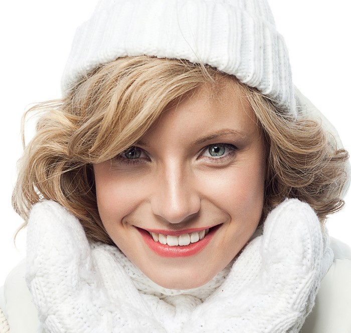 Blonde girl wearing a winter hat and mittens
